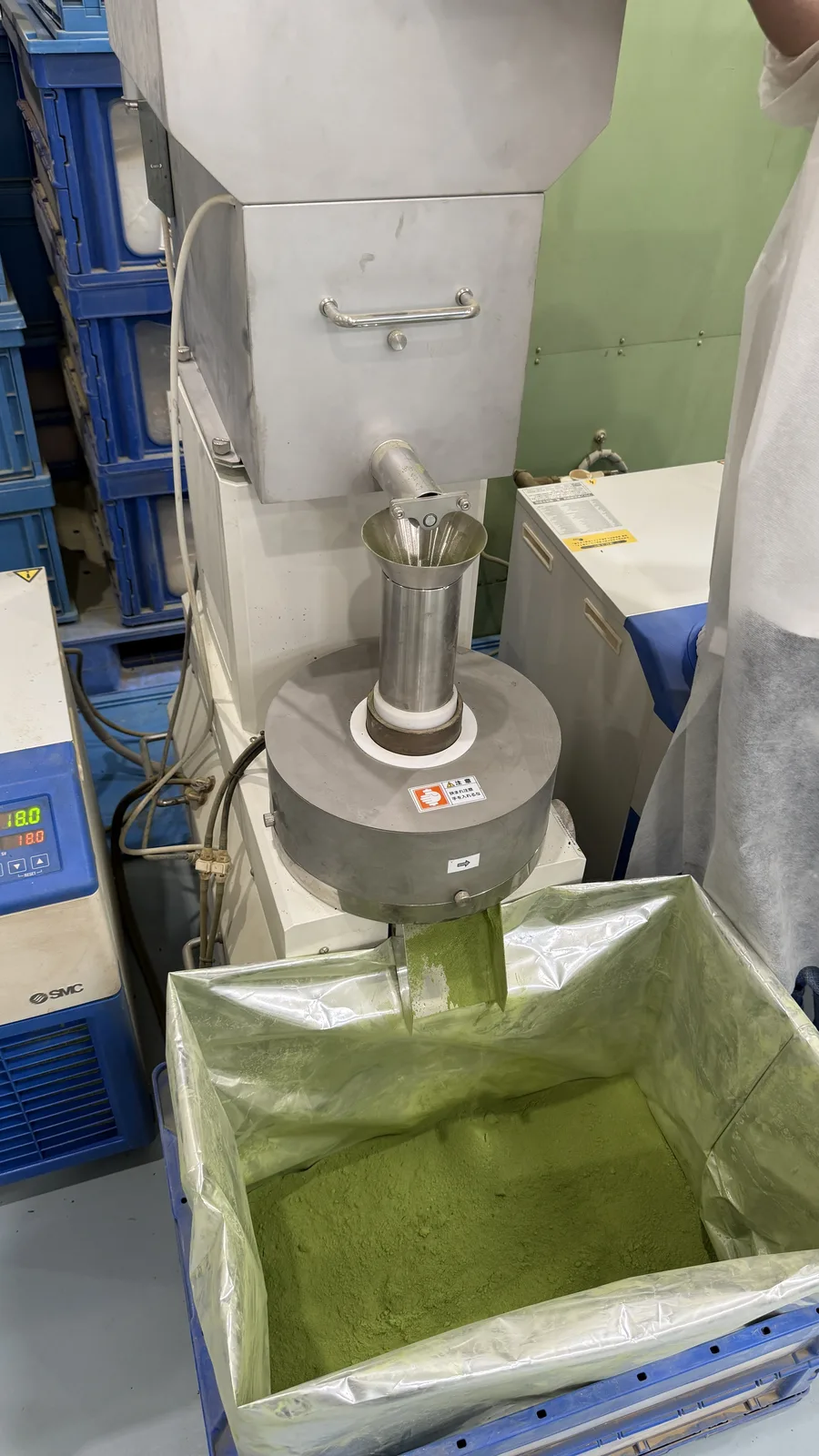 Fresh matcha powder flowing from a stone mill
